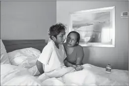  ?? ARIANA DREHSLER — THE NEW YORK TIMES ?? Maria Felix helps her son, Jose Eduardo Martinez, sit up in bed at a hospital in San Diego as he recovers from a crash last month that killed 13 Mexican and Guatemalan migrants. Martinez was one of 12 survivors.