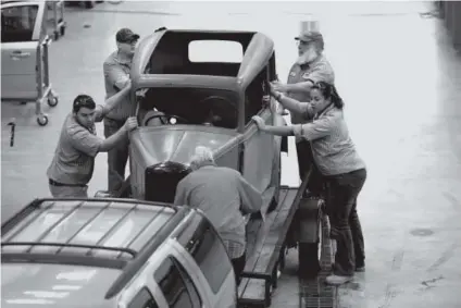  ??  ?? Four people help hobby student John Woodward, 70, foreground, load his 1935 Austin 7 onto a trailer in the garage at Aims Community Colleger in Windsor on Dec. 6. Joe Amon, The Denver Post