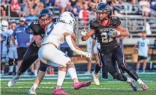  ?? SCOTT ASH / MILWAUKEE JOURNAL SENTINEL ?? Muskego's Ashton Krause follows a block by lineman James Brunner during the team's home game against Oak Creek on Friday.