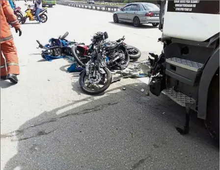  ??  ?? Fatal crash: Damaged motorcycle­s lying on the road where they finally came to rest after the multi-vehicle accident near Lembah Beringin on the North-South Expressway.