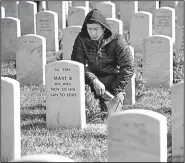  ?? AP/CLIFF OWEN ?? Ken Lai of Berryville, Va., pauses Saturday after placing a wreath at a headstone in Arlington National Cemetery in Arlington, Va., as part of Wreaths Across America.