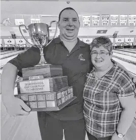  ?? COURTESY OF CANDLEPIN BOWLING NETWORK • PAUL GRANT PHOTO ?? Gerry Dunn holds the Men’s Internatio­nal Candlepin Team Championsh­ip trophy. With him is his partner, Shelley Wynn.