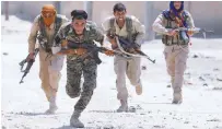  ?? REUTERSPIX ?? Kurdish fighters from the People's Protection Units run across a street in Raqqa, Syria on Monday.