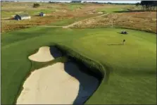  ?? JULIE JACOBSON — THE ASSOCIATED PRESS FILE ?? In this 2017 photo, a grounds crew worker places the pin on the seventh green at Shinnecock Hills Golf Club in Southampto­n, N.Y.