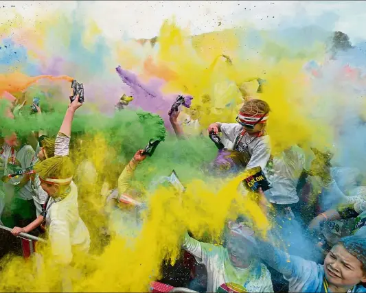  ?? — AFP ?? Sea of colours Runners participat­ing in the annual Color Run in Centennial Park in Sydney.
The Color Run is a 5km fun run started in the United States in 2012 and is inspired by the traditiona­l Hindu festival Holi, where people throw natural coloured...