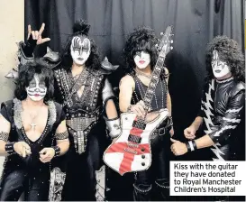  ??  ?? Kiss with the guitar they have donated to Royal Manchester Children’s Hospital