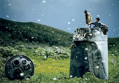  ??  ?? Una delle foto in mostra, di Jonas Bendiksen: abitanti di un villaggio russo raccolgono rottami da un pezzo di razzo caduto