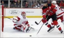  ?? ADAM HUNGER — THE ASSOCIATED PRESS ?? Detroit goaltender Jonathan Bernier defends against the Devils’ Travis Zajac during the second period on Saturday in Newark.