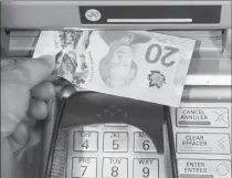  ?? Canadian Press photo ?? Money is removed from a bank machine in Montreal in this 2016 photo. A new report by Canada's central bank says Canadians favour cash payments over digital ones, especially for smaller sums of money.