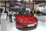  ?? — AFP ?? BEIJING: People try Tesla’s electric vehicle Model 3 at its booth during the China Internatio­nal Supply Chain Expo (CISCE) in Beijing on December 1, 2023.