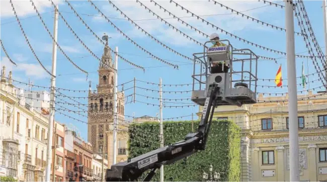  ?? RAÚL DOBLADO ?? Un operario monta las luces de Feria en la plaza de San Francisco