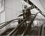  ?? Patrick T. Fallon / Bloomberg ?? An American Airlines employee rides an escalator Thursday at Dallas/FortWorth Internatio­nal Airport as American begins furloughin­g workers.