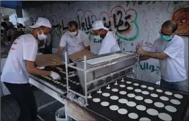  ?? (The Washington Post/Loay Ayyoub) ?? Workers make Ramadan sweets in Al-Galaa Street in Gaza City, Israel. Some coronaviru­s-related restrictio­ns have been relaxed for the holy month’s duration.