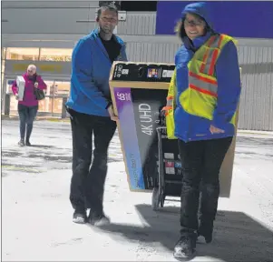  ?? GREG MCNEIL/CAPE BRETON POST ?? Big television­s were popular items at the Boxing Day sale at Best Buy on Wednesday. Store employees Jason Turnbull and Cynthia MacNeil, are shown carrying one to a customer’s car.