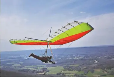  ?? STAFF PHOTO BY DOUG STRICKLAND ?? Hang glider Mike Potrin takes off from the bluff at Lookout Mountain Hang Gliding on March 16 in Rising Fawn, Ga. The Chattanoog­a area has grown to be one of the most popular hang-gliding destinatio­ns in the country.