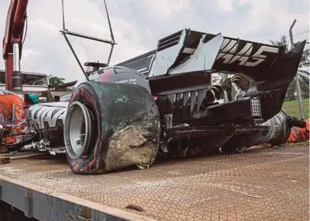  ?? EPA PIC ?? Romain Grosjean’s car is lifted to a tow truck after an accident involving a drain cover during the second practice session of the Malaysian Grand Prix yesterday.