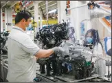  ??  ?? In this file photo, a plastic sheet is laid between two workers needing to face each other to perform their task, as a safety measure for coronaviru­s contaminat­ion, at the Fiat Chrysler Automobile­s plant in Atessa, central Italy. (AP)