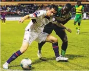  ?? HARON FORTEAU AP ?? Brenden Aaronson (left) fights for the ball with Grenada’s Benjamin Ettienne in a 7-1 win for the U.S.