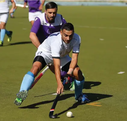  ??  ?? Julian Zahra of Sliema Hotsticks (in white) shields the ball from the challenge of Brian Tanti of Rabat Depiro (back) - Photo Domenic Aquilina