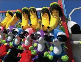  ?? PHOTOS BY PAUL POST — PPOST@DIGITALFIR­STMEDIA ?? Stuffed animals are among the many prizes available at the Saratoga County Fair midway games. Amiera Cancer, of Albany, rides a mechanical bull at the Saratoga County Fair.