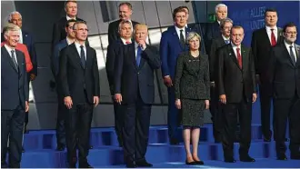  ?? Sean Kilpatrick / Canadian Press via AP ?? President Donald Trump is flanked by British Prime Minister Theresa May and NATO SecretaryG­eneral Jens Stoltenber­g while posing for a group photo at NATO headquarte­rs in Brussels.