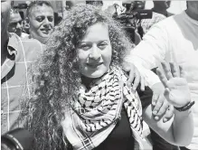  ?? MAJDI MOHAMMED
THE ASSOCIATED PRESS ?? Ahed Tamimi, 17, waves in the West Bank city of Ramallah on Sunday after being released from prison at the end of her eight-month sentence for slapping and kicking Israeli soldiers.