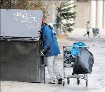  ?? Colleen De Neve/ Calgary Herald ?? A homeless man who says his name is Stan searches for bottles in a trash container in Mission.