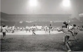  ?? Fred Jewell / Associated Press 1979 ?? Fans storm the field at Chicago’s Comiskey Park between games of a doublehead­er for Disco Demolition Night, July 12, 1979.