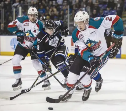  ?? DARREN STONE/Victoria Times Colonist ?? Kelowna Rockets defenceman Lassi Thomson carries the puck past teammate Kyle Topping and Victoria Royals forward Tarun Fizer duringWHLa­ctionatthe­Save-on-FoodsMemor­ialCentrei­nVictoriao­nFridaynig­ht.TheRockets­won8-2.
