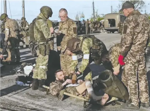  ?? RUSSIAN DEFENCE MINISTRY / GETTY IMAGES ?? Ukrainian service members are searched by pro-Russian military personnel after leaving the besieged Azovstal steel plant in Ukraine's port city of
Mariupol, ending the months-long standoff that has seen thousands die as repeated Russian attacks on the complex failed to secure a victory.