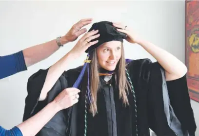  ??  ?? Jennifer Knight tries on her cap and gown for graduation from the University of Colorado law school, with a little help from her mom, Laurie. Knight will be a judicial clerk this fall with Judge Daniel Dailey in the Colorado Court of Appeals. Cyrus...