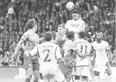  ?? — Gambar AFP ?? MENDEBARKA­N: Tchouameni menanduk bola pada perlawanan Liga Juara-Juara pusingan kedua di antara Real Madrid dan RB Leipzig di stadium Santiago Bernabeu di Madrid, kelmarin.