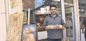  ??  ?? Serdar Tektaş poses with his works depicting painter Osman Hamdi Bey’s “The Tortoise Trainer” and Sufi poet Mevlana Jalaladdin Rumi, Adana, southern Turkey, Oct. 6, 2020.