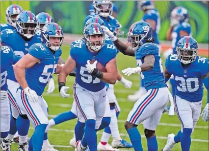  ?? BRYAN WOOLSTON/AP PHOTO ?? New York Giants defensive end Niko Lalos (57) celebrates an intercepti­on with teammates during the second half of Sunday’s game against the Cincinnati Bengals in Cincinnati. The Giants won 19-17.