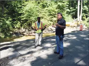  ??  ?? Stamford Traffic Department Operations Foreman Orazio Cirelli, right, assesses storm damage at Farms Road, which will remain closed while repairs are made.