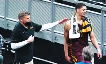  ?? AP PHOTO BY MARK HUMPHREY ?? Loyola-Chicago men’s basketball coach Porter Moser, left, walks off the court with Lucas Williamson after the eighth-seeded Ramblers beat top-seeded Illinois in the second round of the NCAA tournament Sunday in Indianapol­is.