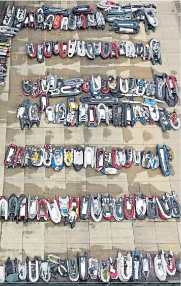  ??  ?? Boats used by migrants are stored at a warehouse in Dover, Kent, after being intercepte­d in the Channel by Border Force