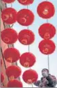  ?? AFP ?? A man installs Chinese lanterns ahead of the Lunar New Year, in Beijing.