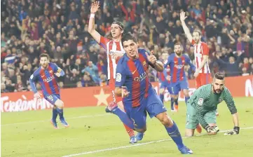  ??  ?? Barcelona’s Luis Suarez celebrates after scoring their first goal during the Spanish Copa del Rey (King’s Cup) semi final second leg football match against Club Atletico de Madrid at the Camp Nou stadium in Barcelona. — Reuters photo