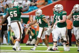  ?? ALLEN EYESTONE / THE PALM BEACH POST ?? Running back Travis Homer is congratula­ted by offensive lineman Navaughn Donaldson after a touchdown run against Toledo.