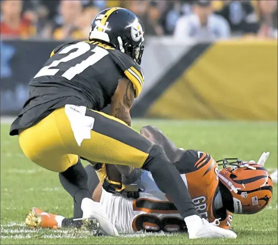  ?? Matt Freed/Post-Gazette ?? Joe Haden scoops up his first intercepti­on as a member of the Steelers — a pass intended for Bengals receiver A.J. Green in the third quarter.
