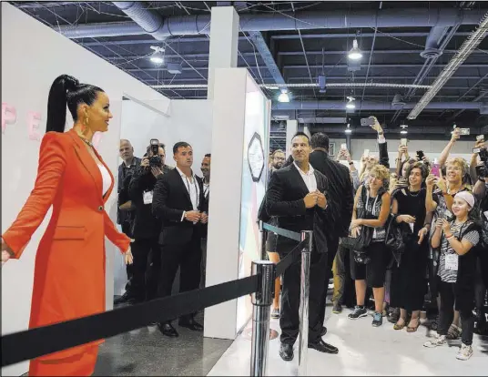  ?? MARTIN S. FUENTES/LAS VEGAS REVIEW-JOURNAL ?? Musical artist Katy Perry greets the crowd from her booth during the MAGIC trade show Aug. 15 inside the Las Vegas Convention Center. This week’s show is expected to draw 85,000 attendees.