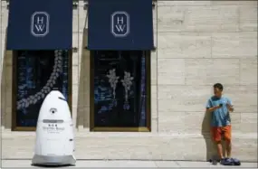  ?? THE ASSOCIATED PRESS ?? A new security robot, nicknamed ROD2, drives toward Daniel Webb as it patrols the sidewalks and parking garage Aug. 18 at River Oaks District in Houston. The robot recently became the latest addition to a patrol team eager to experiment with...