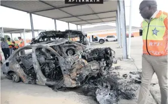  ?? DOCTOR NGCOBO ?? AFTERMATH TRANSPORT, Community Safety and Liaison MEC Mxolisi Kaunda surveys a burnt-out Mercedes-Benz and minibus taxi that were involved in a collision killing 15 people on the N2 between Empangeni and Mtubatuba. |