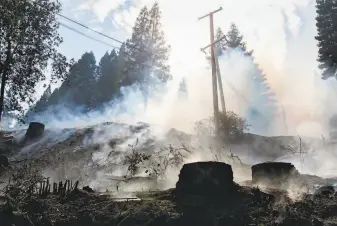  ?? Brittany Hosea-Small / Special to the Chronicle ?? Smoke rises from the charred ground Saturday along Mill Creek Road in Healdsburg. Noah Dorrance says he can already taste the effects of smoke on some of the grapes in the area.