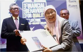  ??  ?? Spotlight on finance: Dr Wan Azizah launching AKPK’S inaugural financial behaviour survey report at its Financial Literacy Symposium 2018. Looking on is AKPK chairman Anuar Mohd Hassan (back) and Azaddin. — Bernama