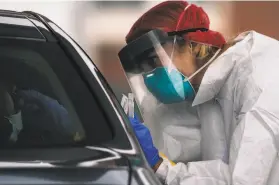  ?? Stephen Lam / Special to The Chronicle ?? A worker collects a sample to screen for the coronaviru­s in S.F. this month.