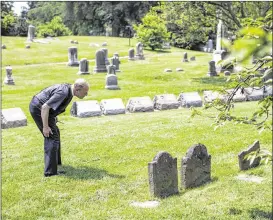  ?? JUSTIN GILLILAND / THE NEW YORK TIMES ?? Old First Reformed Church’s the Rev. Daniel Meeter reads a grave marker on the circle of property Old First sold to Green-Wood Cemetery in Brooklyn, New York — the land is essentiall­y a cemetery within a cemetery. The church did not need the plots that...