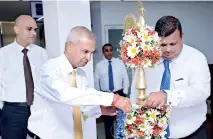  ??  ?? Independen­t Non-executive Director Lakshman Jayarathne lighting the oil lamp at the Kegalle branch opening in the presence of Ceo/director Krishan Thilakarat­ne and Branch Manager Pradeep Wijayanand­ana