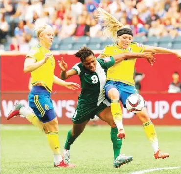  ??  ?? Elin Rubensson (R) of Sweden vies with Desire Oparanozie (C) of Nigeria during their group D match at the 2015 FIFA Women’s World Cup in Winnipeg, Canada
